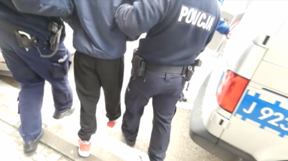 Policjanci prowadzą zatrzymanego męźczyznę