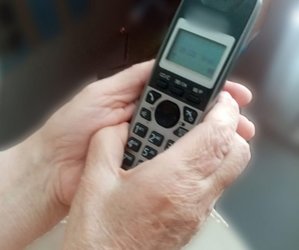 łonie kobiety, która trzyma słuchawkę telefonu
