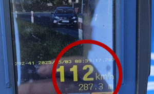 Zdjęcie w kolorze przedstawia ekran miernika prędkości ze zdjęciem pojazdu i wskazana prędkością 112 km/h