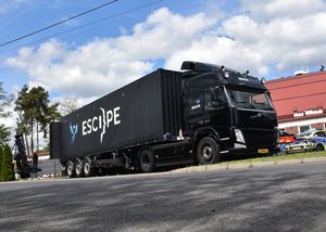 Zdjęcie w kolorze przedstawia czarny pojazd ciężarowy zaparkowany przy centrum sportu Kotwica