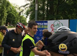 Zdjęcie w kolorze przedstawia uczestników wydarzenia podczas zapisów. NA pierwszym planie kask z naklejka z uśmiechniętą buzią z napisem policja.