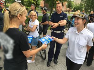 Zdjęcie w kolorze przedstawia dwie uśmiechnięte kobiety oraz umundurowanego policjanta.