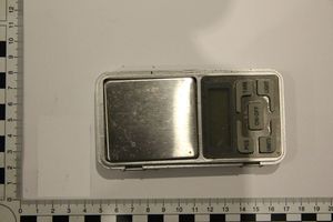 Zdjęcie w kolorze przedstawia wagę jubilerską elektroniczną. w lewym dolnym rogu miara ze skalą.