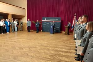 Zdjęci ew kolorze przedstawia uroczystość z okazji Święta Policji w Oleśnie. Policjanci stoją po prawej stronie w Dwuszeregu na środku Komendanci : Powiatowy i Zastępca Komendanta Wojewódzkiego, po lewej przedstawiciele instytucji i władz lokalnych.