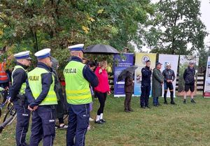 Zdjęcie w kolorze przedstawia po lewej stronie policjantów w kamizelkach odblaskowych, dalej na wprost od lewej Komendant Powiatowy Policji w Oleśnie, Senator RP Beniamin Godyla, Burmistrz Olesna Piotr Gręda, Dyrektor PSP nr 1 w Oleśnie Adam Adamski.