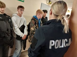 Zdjęcie w kolorze przedstawia policjantkę oprowadzająca młodzież w pomieszczeniach dla osób zatrzymanych KPP w Oleśnie.