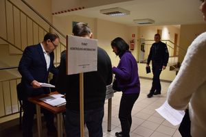 Zdjęcie w kolorze przedstawia punkt kontrolno informacyjny przy którym stoja cywile.