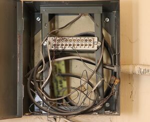 Zdjęcie w kolorze przedstawia otwartą skrzynkę z przewodami elektrycznymi.