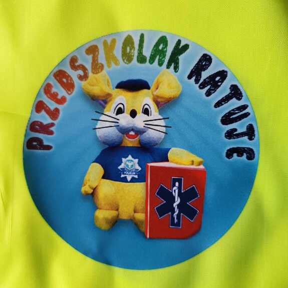 zdjęcie w kolorze przedstawia logo programu przedszkolak ratuje, na którym widnieje maskotka opolskiej policji - zając policuś z torbą medyczną do koła niego napis przedszkolak ratuje.