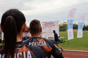 Zdjęcie w kolorze przedstawia sportowców w koszulkach z napisem POLICJA w tle scena z napisem 28. Biegi Pokoju