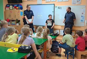 Zdjęcie w kolorze przedstawia spotkanie dzieci z policjantami w klasie.