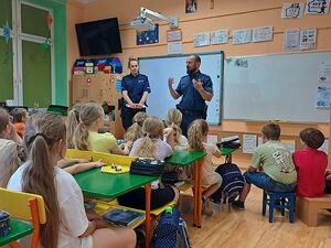 Zdjęcie w kolorze przedstawia spotkanie dzieci z policjantami w klasie.