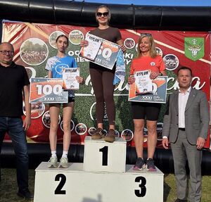 Zdjęcie w kolorze, przedstawia kobiety w strojach sportowych stojące na podium.