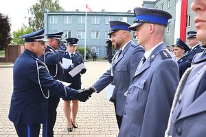 Zdjęcie w kolorze przedstawia pełniącego obowiązki Komendanta Powiatowego Policji w Oleśnie oraz Zastępcę Komendanta Wojewódzkiego Policji w Opolu podczas wręczania   policjantom nominacji na wyższe stopnie.