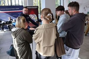 Na zdjęciu widać umundurowanego policjanta który rozmawia z czterema osobami.