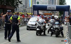 Policjanci ruchu drogowego przed linią startu. Obok stoją policyjne motocykle i radiowóz