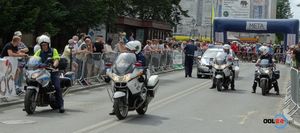 cztery policyjne motocykle i radiowóz pilotują kolarzy po starcie
