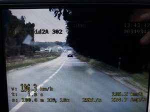 Widok  monitora video rejestratora z wskaźnikiem prędkości 196.4 km/h , na którym widać oddalający się pojazd.