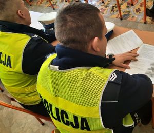 Policjant w mundurze przegląda testy z ruchu drogowego.