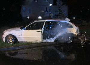 Biały samochód osobowy z uszkodzonym lewym bokiem po wypadku drogowym.