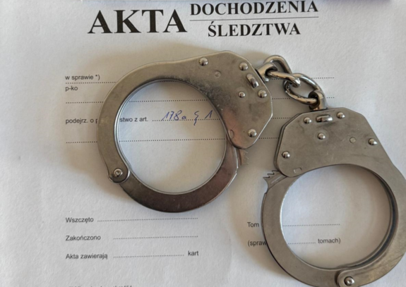kajdanki leżące na teczce akt sprawy