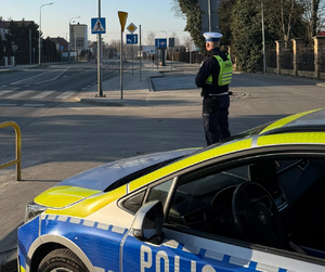 umundurowany policjant przy radiowozie