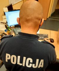 Łysy policjant siedzi przy biurku