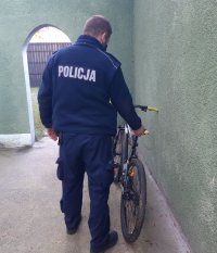 Policjant stoi przy rowerze górskim.