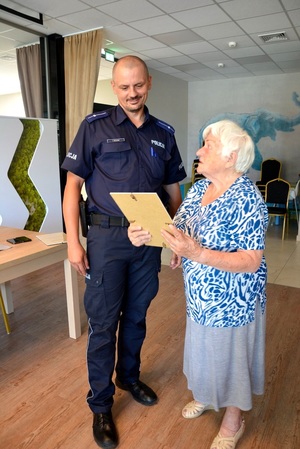 policjant odbierający podziękowania od seniorki