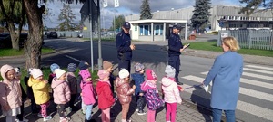 policjant z dziećmi na przejściu dla pieszych