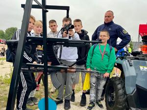 policjant pokazujący młodzieży sprzęt wykorzystywany na co dzień w służbie
