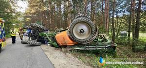 ciągnik z opryskiwaczem lezący na boku