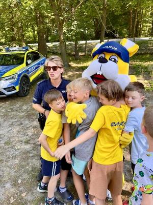dzieci przytulają policusia, obok policjantka
