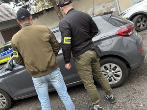 policjanci stojący przy aucie