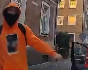 Zamaskowany mężczyzna w pomarańczowej bluzie.