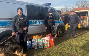 policjanci z karmą przy radiowozie i pies Atos
