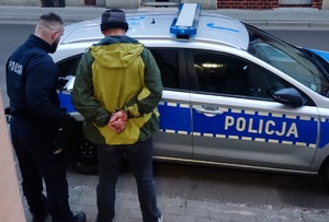 mężczyzna zatrzymany przy radiowozie z policjantem