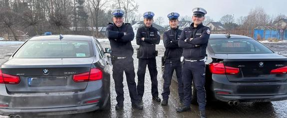 Policjanci przy radiowozach nieoznakowanych