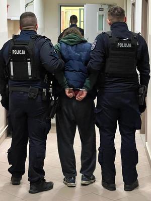 zatrzymany mężczyzna prowadzony przez policjantów