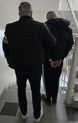 zatrzymany prowadzony przez policjanta