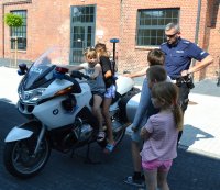 dzieci siedzące na motocyklu policyjnym