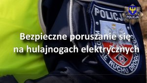 zrzut ekranu z video na którym widzimy napis bezpieczne poruszanie się na hulajnodze elektrycznej, gdzie w tle jest umundurowany policjant ruchu drogowego