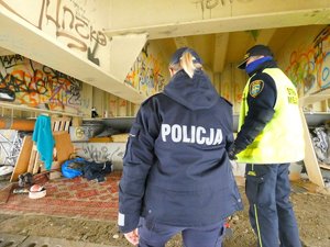 policjanta i strażnik miejski kontrolują miejsce przebywania bezdomnych