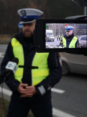 policjant stoi przed kamerą i udziela informacji