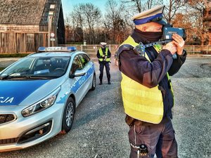 radiowóz a obok dwóch policjantów