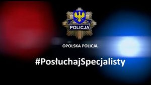 plansza z napisem #PosłuchajSpecjalisty, logo opolskiej policji, napisem opolska policja i niebiesko-czerwonymi światłami