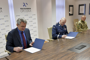przy stole siedzą 3 osoby i podpisują porozumienie: komendant, rektor i dowódca kontrterrorystów