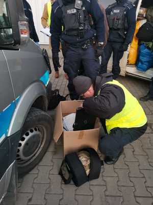 policjanci z zatrzymanymi osobami i zabezpieczonymi rzeczami