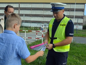 policjanci rozdają odblaski uczniom w pierwszym dniu ich szkoły