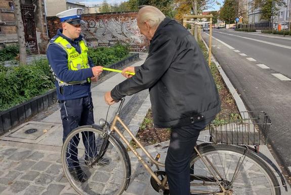 policjant wręcza odblask rowerzyście